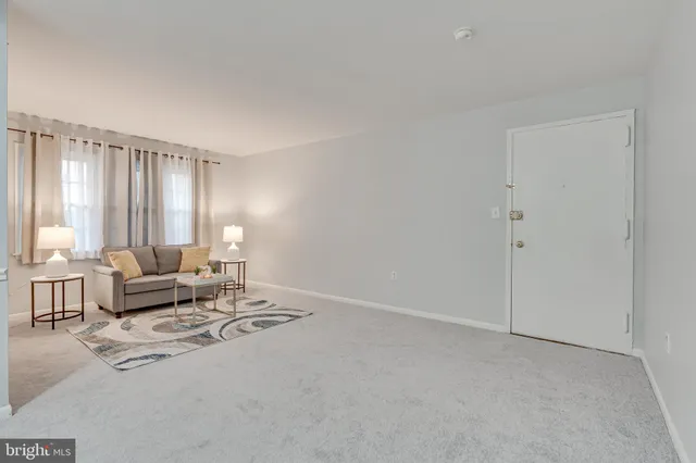 a living room with furniture and large windows
