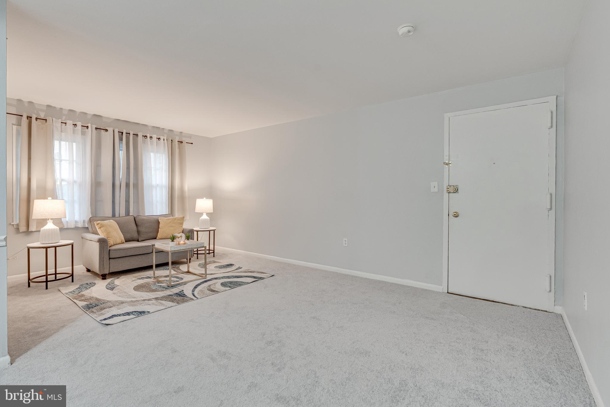 9473 Fairfax Boulevard, Unit 104 Fairfax, VA 22031 - Photo 4 of 32 a living room with furniture and large windows