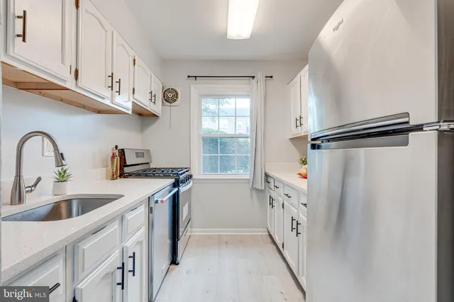 a kitchen with a sink a refrigerator and cabinets