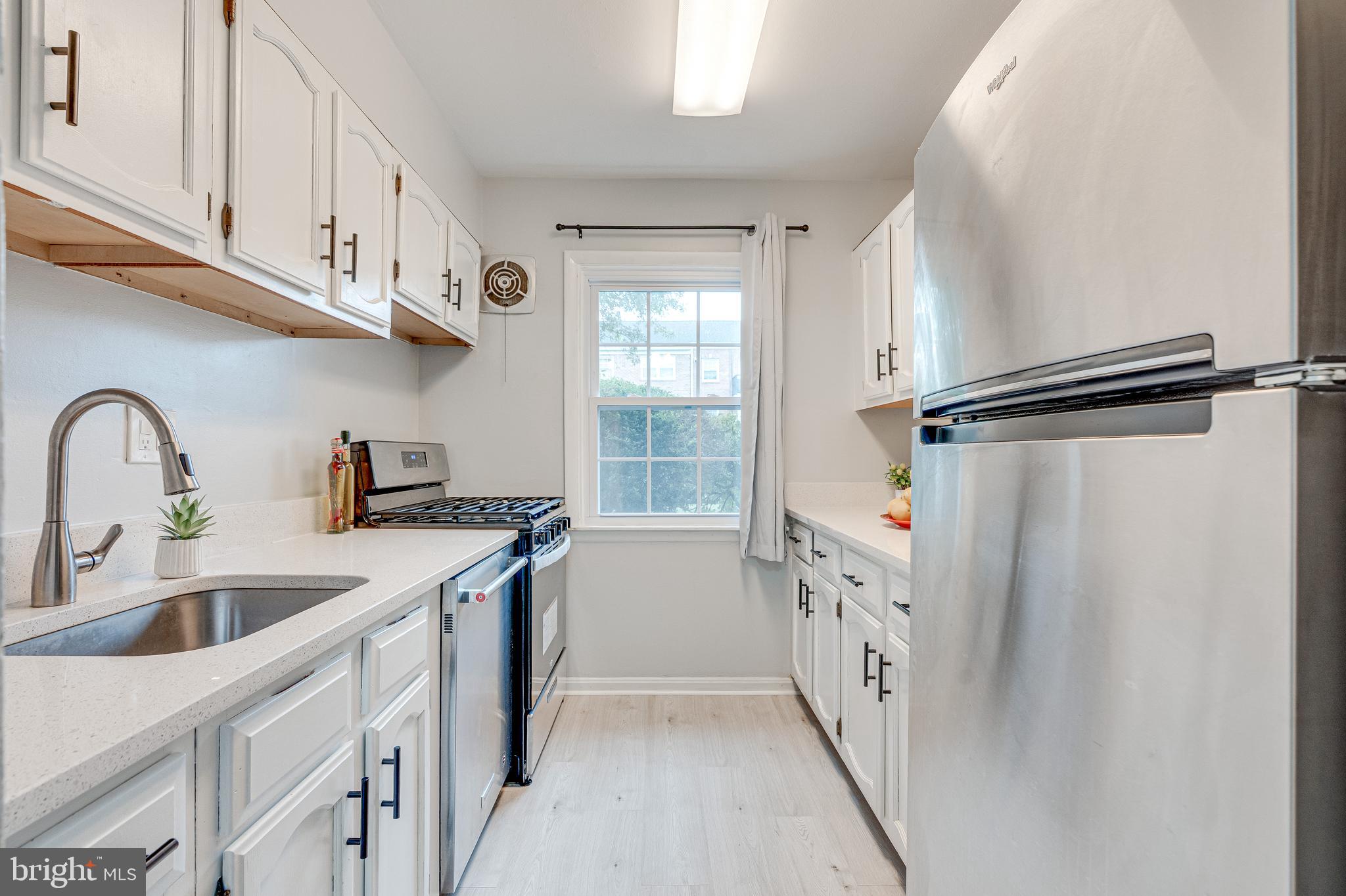 9473 Fairfax Boulevard, Unit 104 Fairfax, VA 22031 - Photo 9 of 32 a kitchen with a sink a refrigerator and cabinets