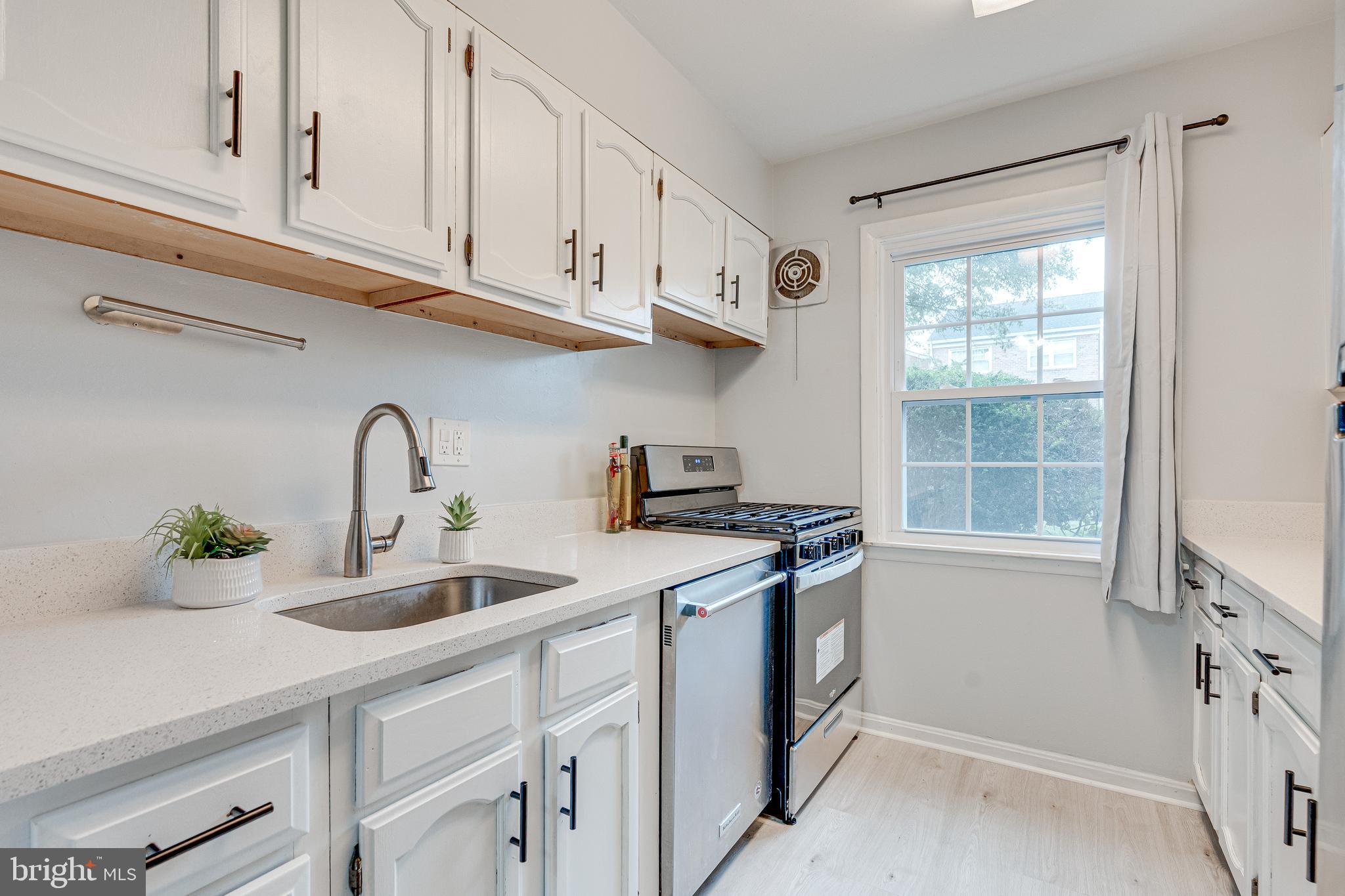 9473 Fairfax Boulevard, Unit 104 Fairfax, VA 22031 - Photo 10 of 32 a kitchen with stainless steel appliances granite countertop a sink a stove and a window