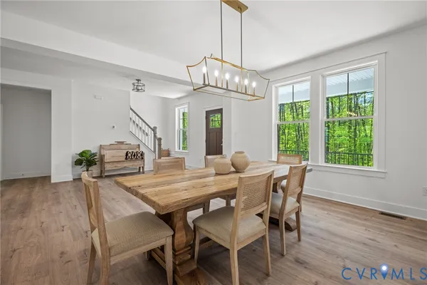 a view of a dining room with furniture a chandelier and wooden floor