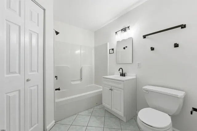 a bathroom with a toilet a sink a mirror a bathtub and shower