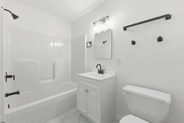 a bathroom with a toilet a sink a mirror a bathtub and vanity