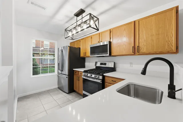 a kitchen with stainless steel appliances a stove sink and microwave