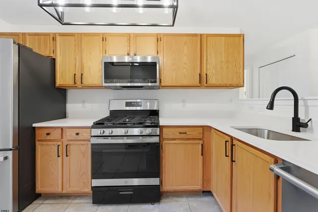 a kitchen with stainless steel appliances a stove a sink and a microwave