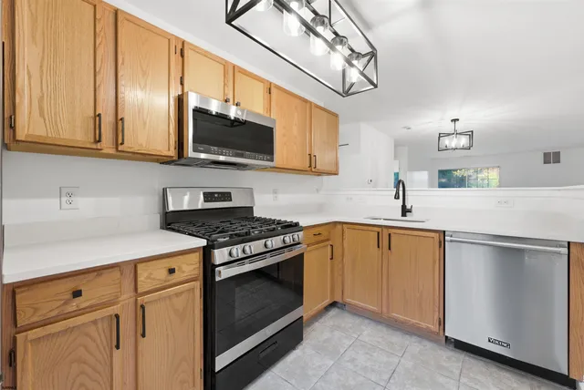 a kitchen with stainless steel appliances granite countertop a sink a stove a microwave and cabinets