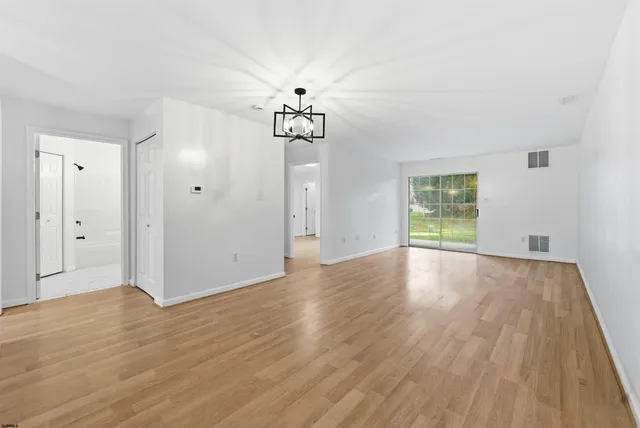 a view of a room with wooden floor and window