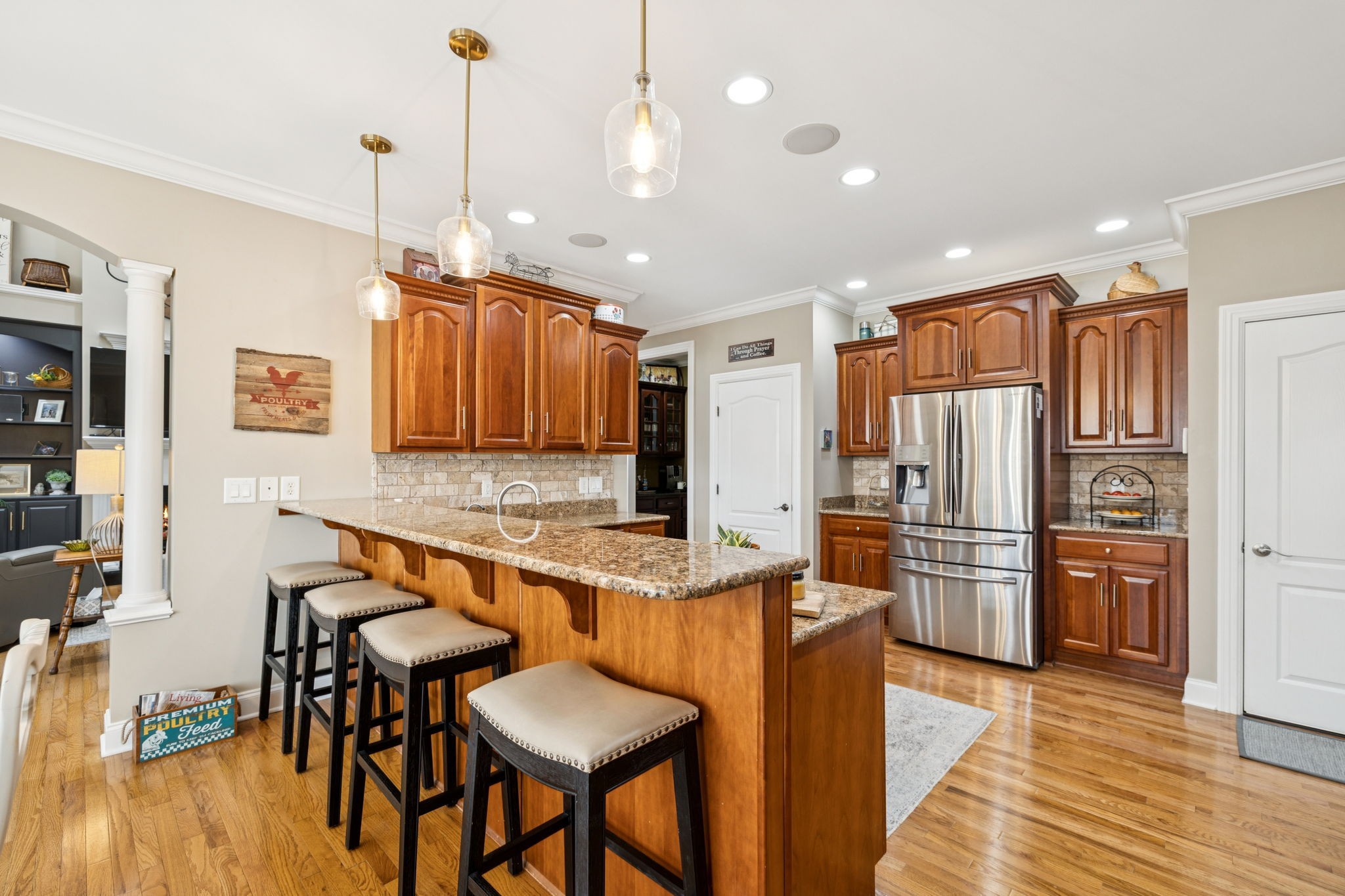 3056 Southeast Tater Peeler Road Lebanon, TN 37090 - Photo 40 of 100 a kitchen with stainless steel appliances granite countertop a refrigerator a sink dishwasher a stove and a dining table with wooden floor