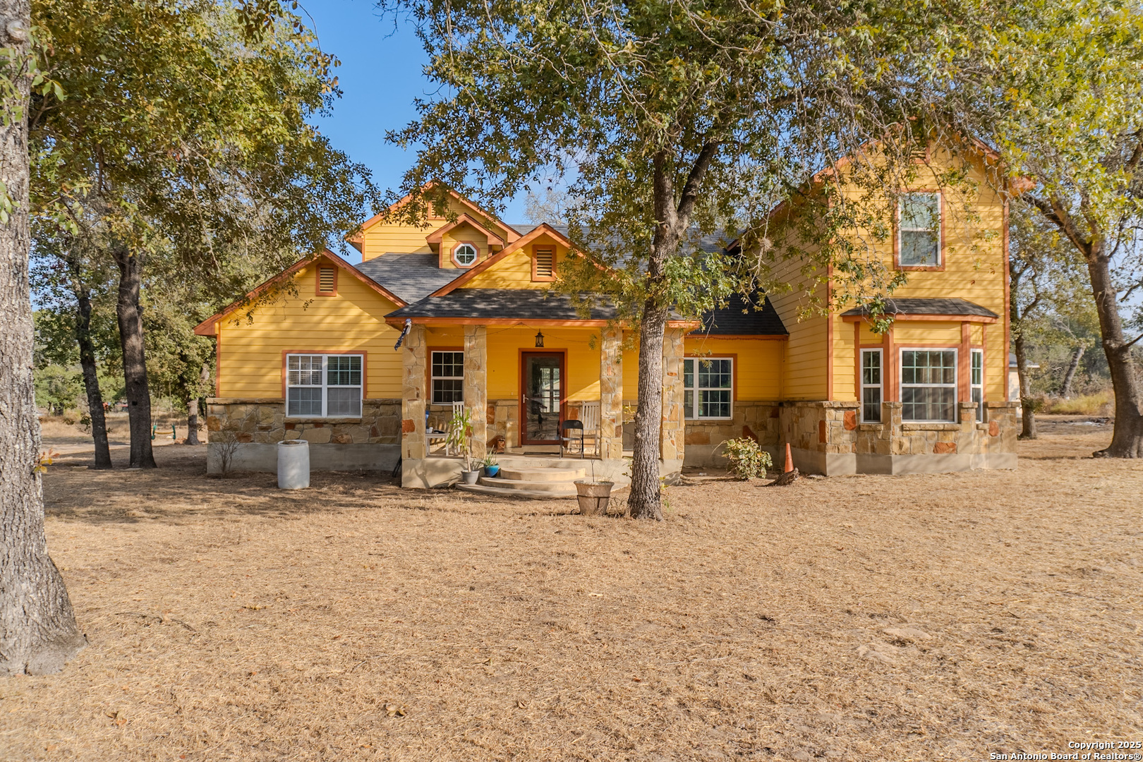 a view of a house with large tree in front of it