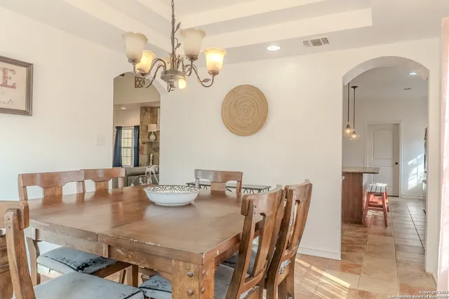 a view of a dining room with furniture and a chandelier