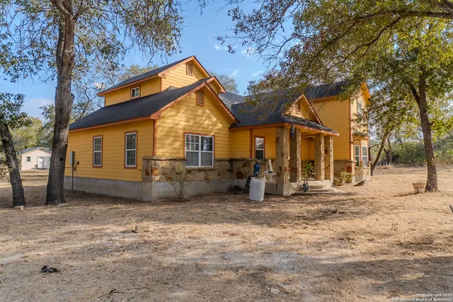 a view of a house with a large tree and a yard