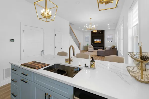 a kitchen with a white cabinets and chandelier