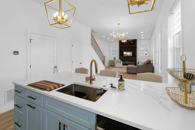 a kitchen with a white cabinets and chandelier