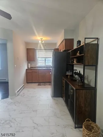 a kitchen with granite countertop a refrigerator and a stove top oven