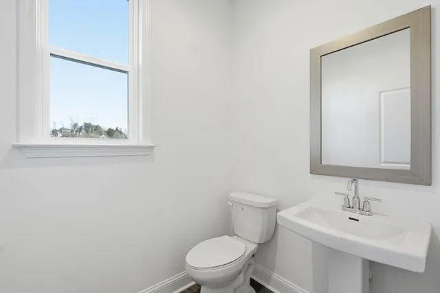 a bathroom with a toilet a sink and a mirror