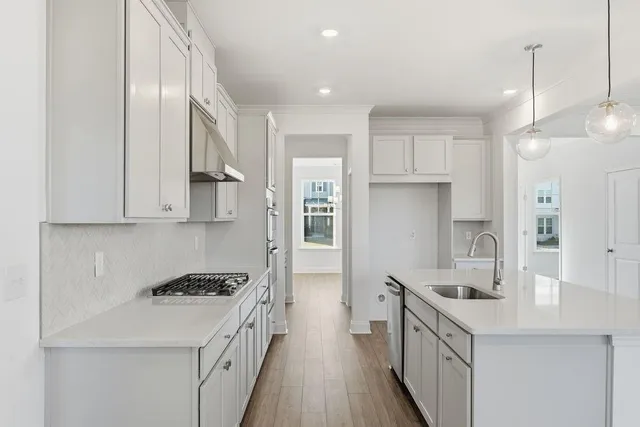 a kitchen with a sink stove top oven and refrigerator