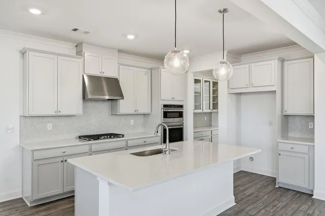 a kitchen with stainless steel appliances a stove a sink and a refrigerator