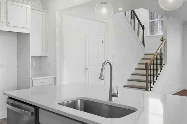 a kitchen with a sink and white cabinets