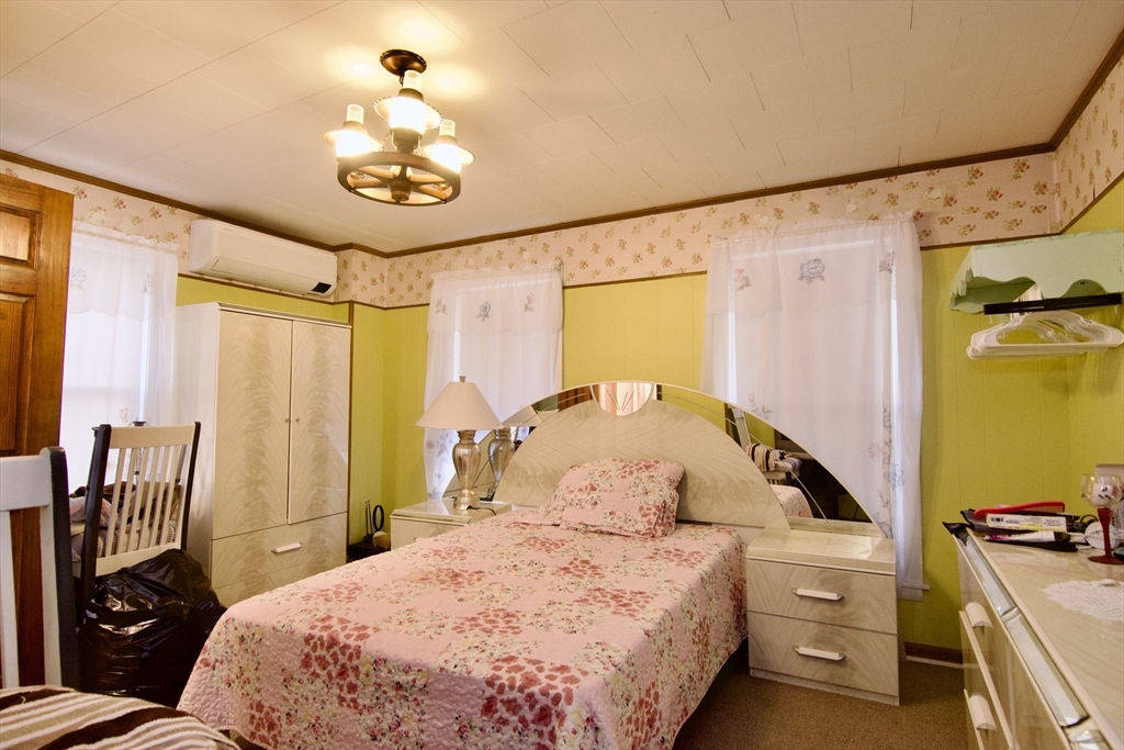 156 Allen Street Springfield, MA 01108 - Photo 16 of 31 a bedroom with a bed and a chandelier