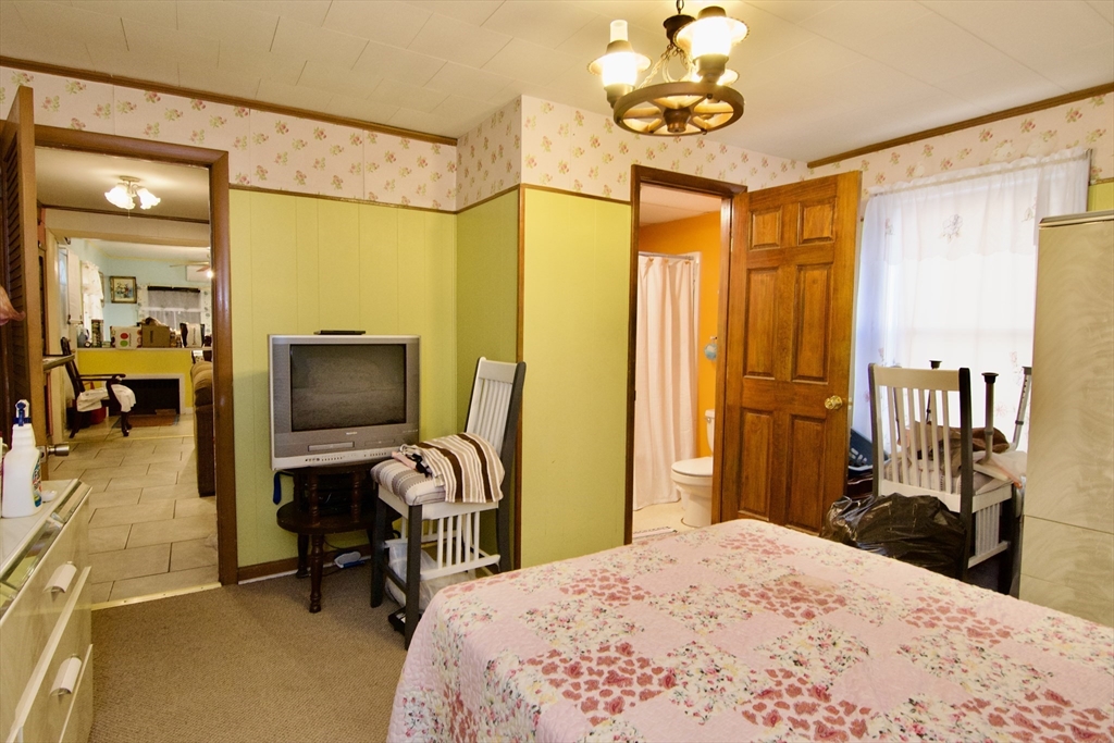 156 Allen Street Springfield, MA 01108 - Photo 18 of 31 a bedroom with a bed and a flat tv screen on wall