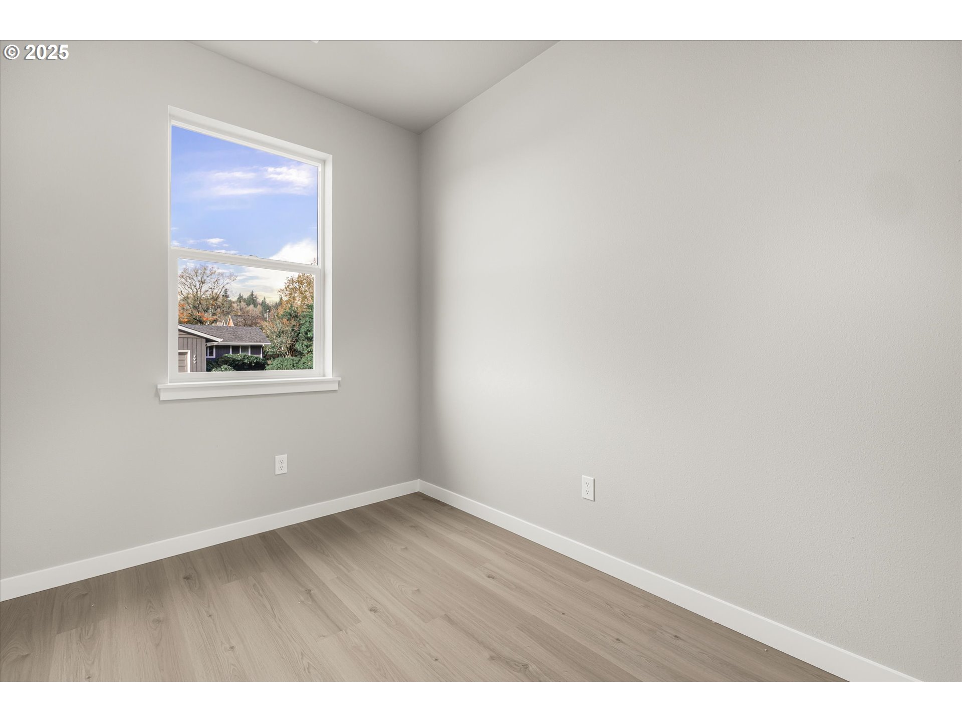 296 Southwest Mawrcrest Avenue Gresham, OR 97030 - Photo 9 of 35 a view of an empty room with wooden floor and a window