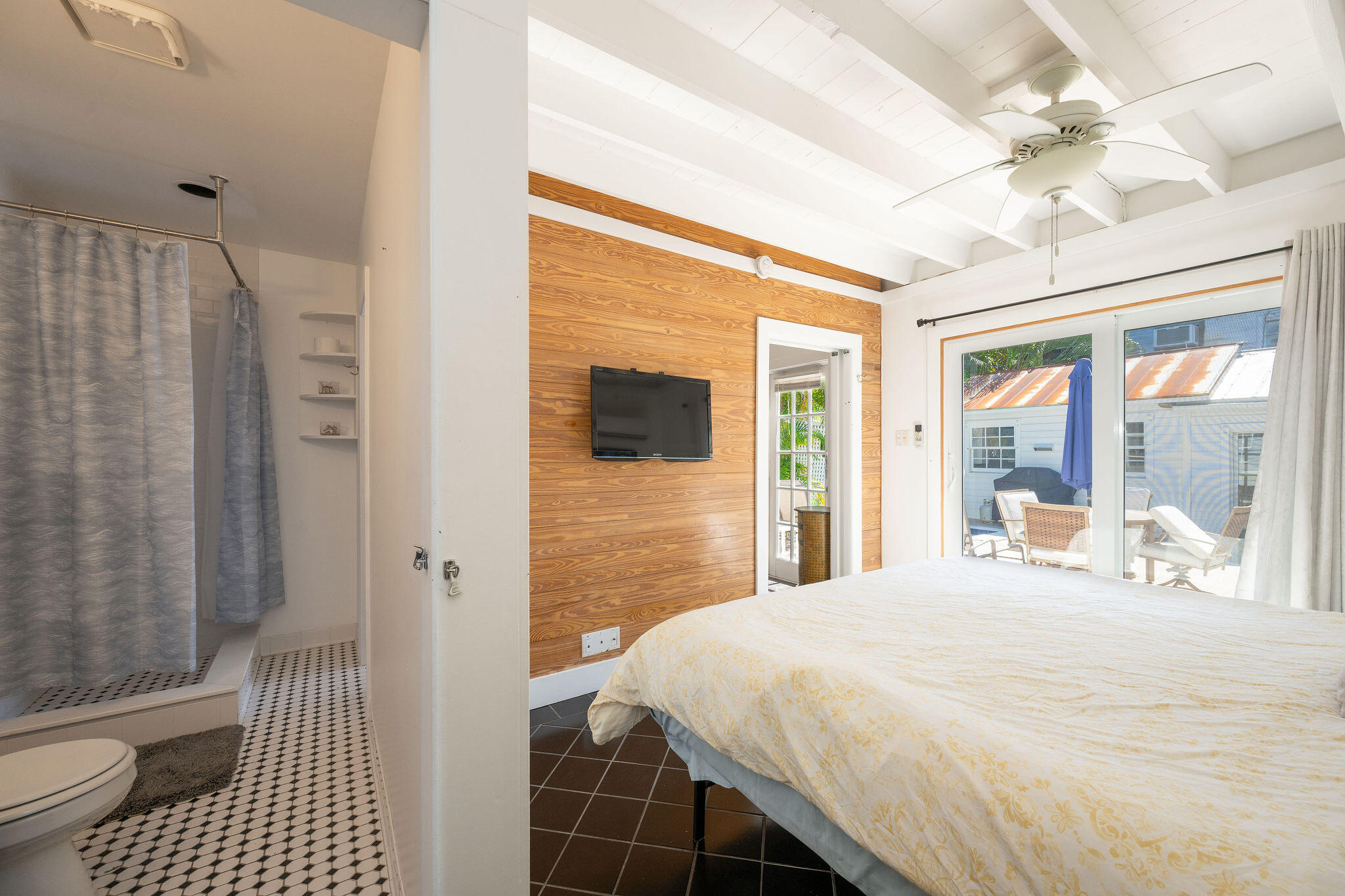 912 James Street, Unit 2 Key West, FL 33040 - Photo 13 of 25 a bedroom with a bed and a walk in closet with wooden floor