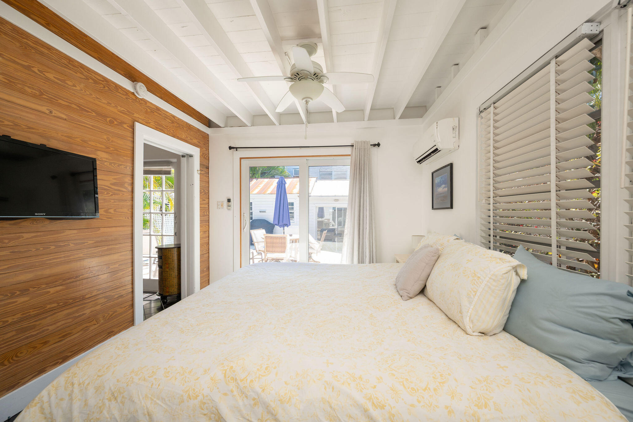 912 James Street, Unit 2 Key West, FL 33040 - Photo 14 of 25 a bedroom with a bed wooden floor and flat screen tv