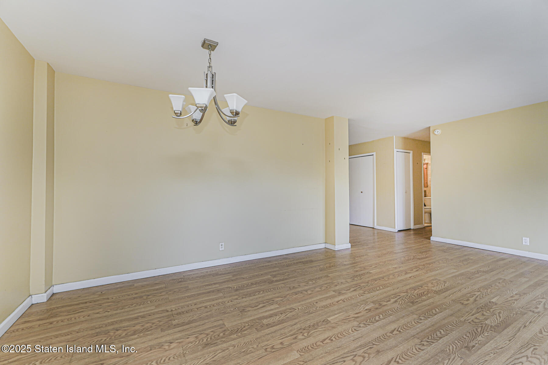 1100 Clove Road, Unit 60 Staten Island, NY 10301 - Photo 13 of 25 a view of an empty room with wooden floor and a window