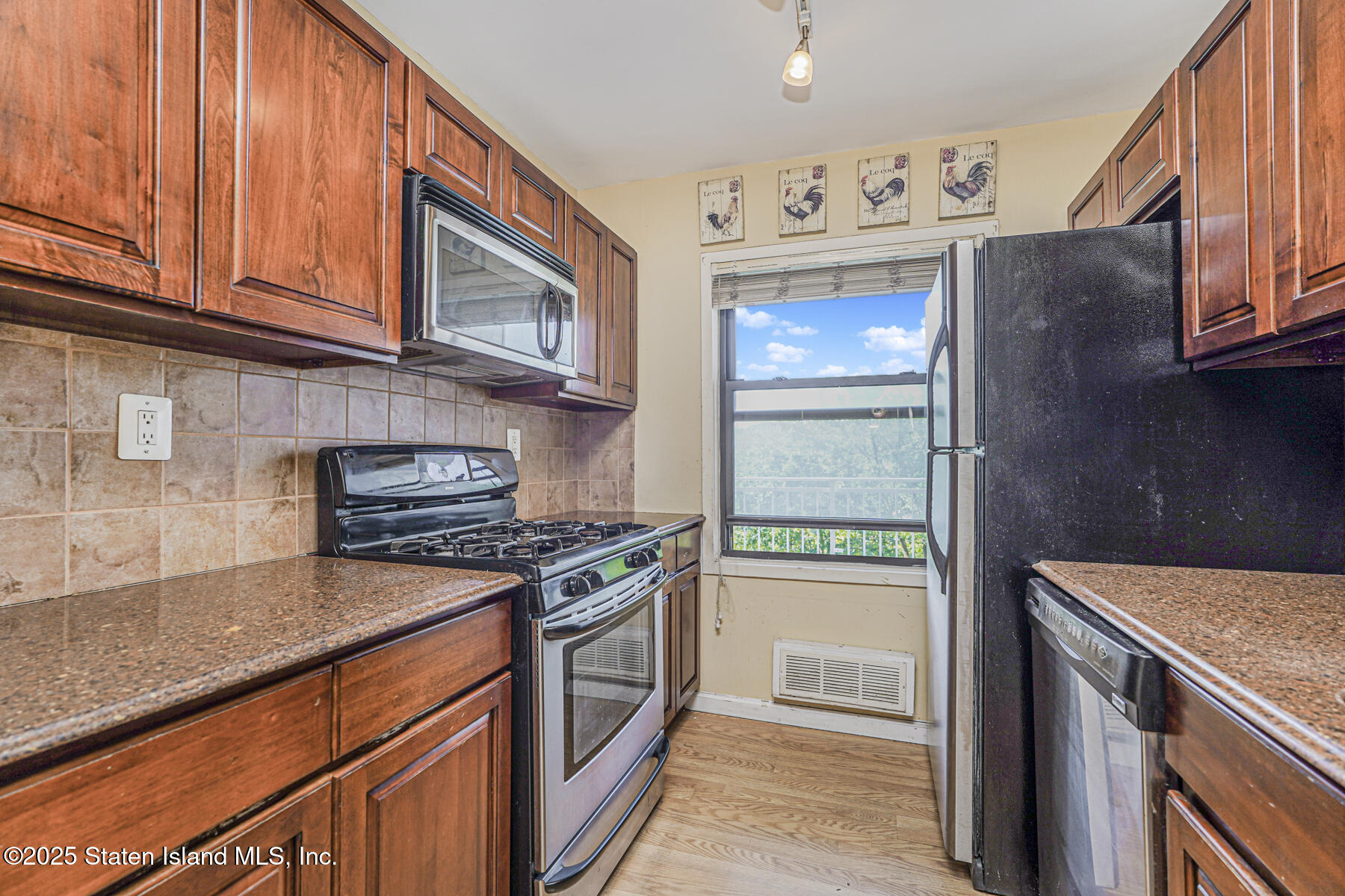 1100 Clove Road, Unit 60 Staten Island, NY 10301 - Photo 14 of 25 a kitchen with granite countertop cabinets stainless steel appliances and a counter space