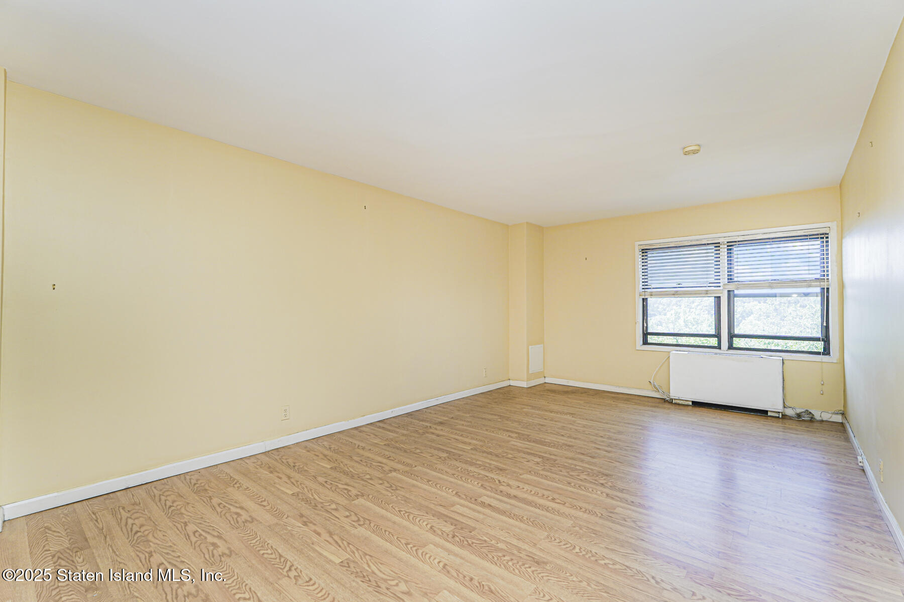 1100 Clove Road, Unit 60 Staten Island, NY 10301 - Photo 23 of 25 an empty room with wooden floor and windows