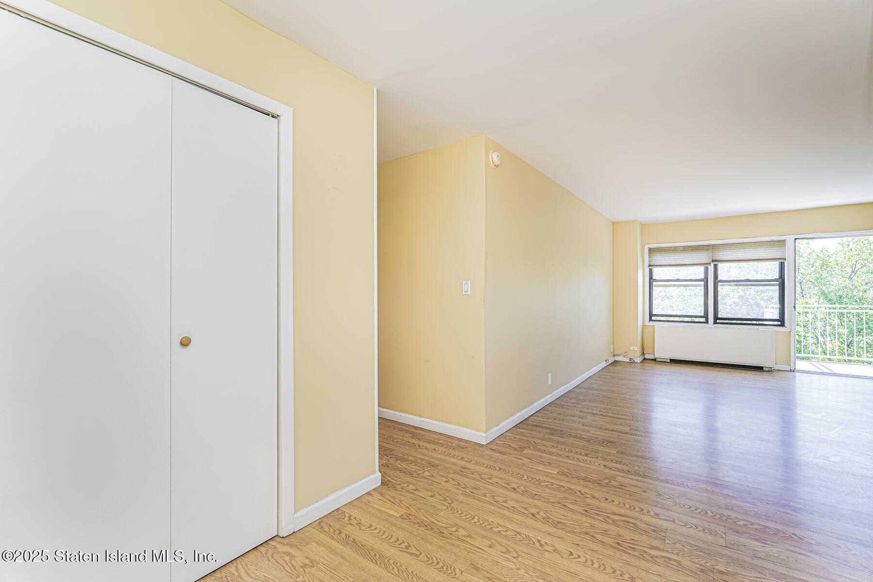 1100 Clove Road, Unit 60 Staten Island, NY 10301 - Photo 6 of 25 a view of an empty room with wooden floor and a window