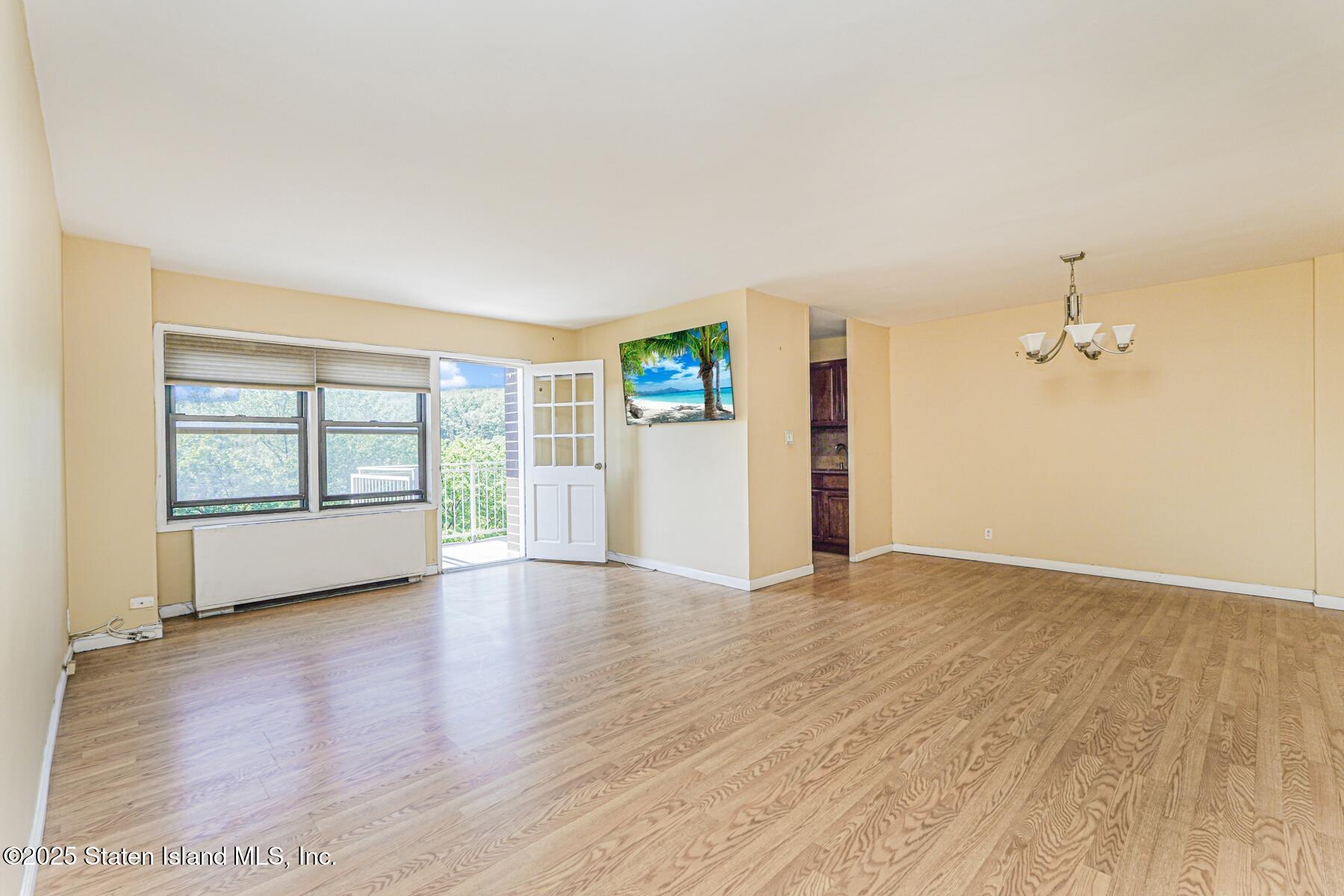 1100 Clove Road, Unit 60 Staten Island, NY 10301 - Photo 7 of 25 a view of empty room with wooden floor and fan