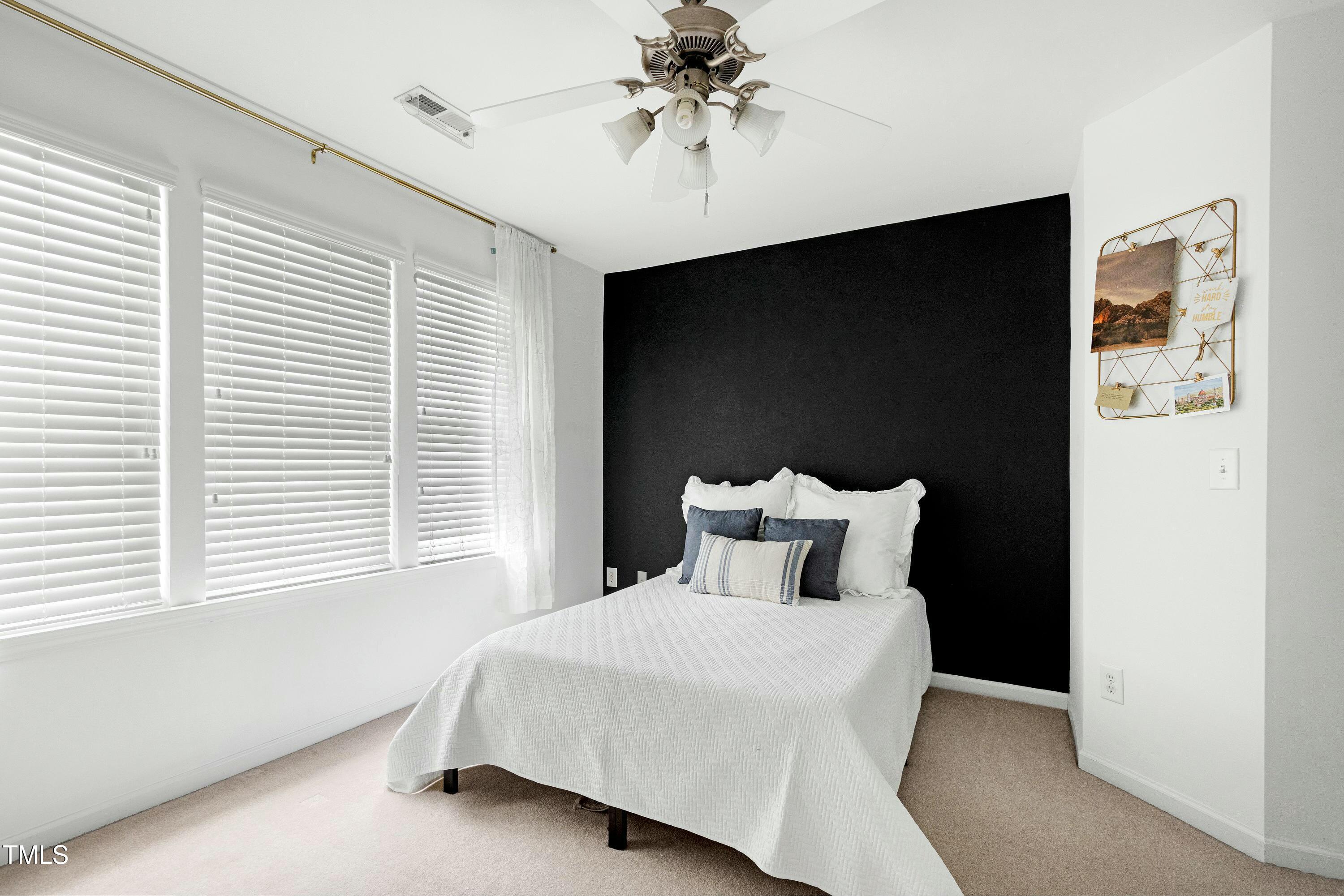 4835 Sir Duncan Way Raleigh, NC 27612 - Photo 19 of 30 a bedroom with a bed and a chandelier