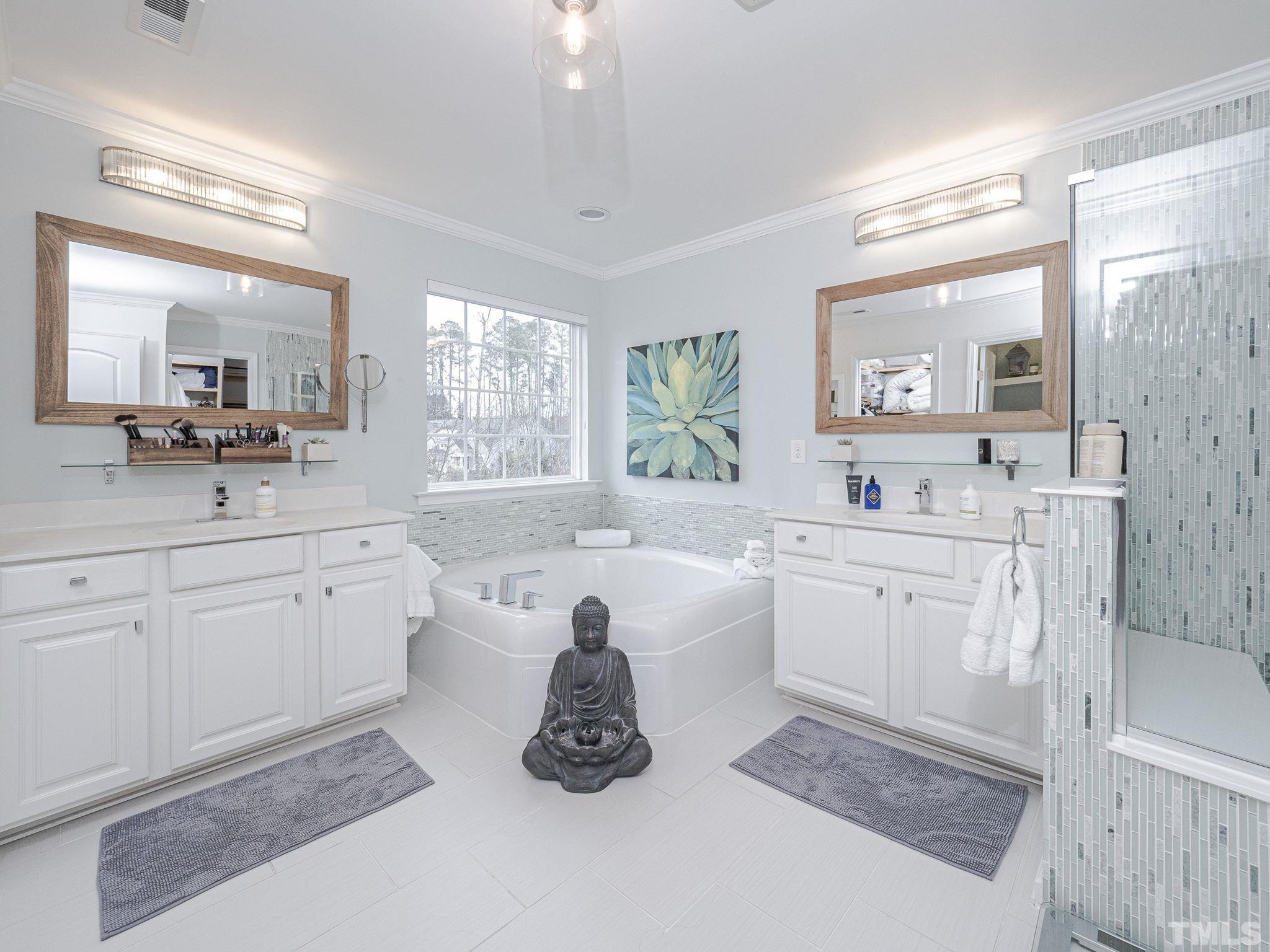 1990 Mostyn Lane Apex, NC 27502 - Photo 26 of 41 a bathroom with a tub sink double vanity and mirror