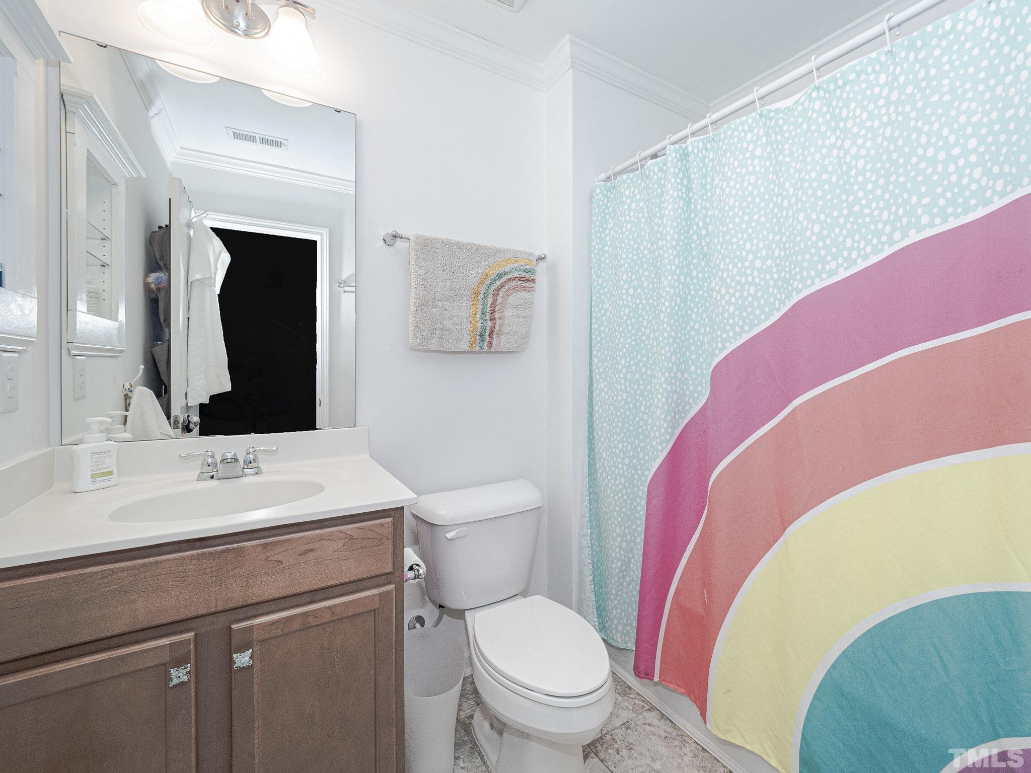 1990 Mostyn Lane Apex, NC 27502 - Photo 34 of 41 a bathroom with a toilet sink vanity and mirror