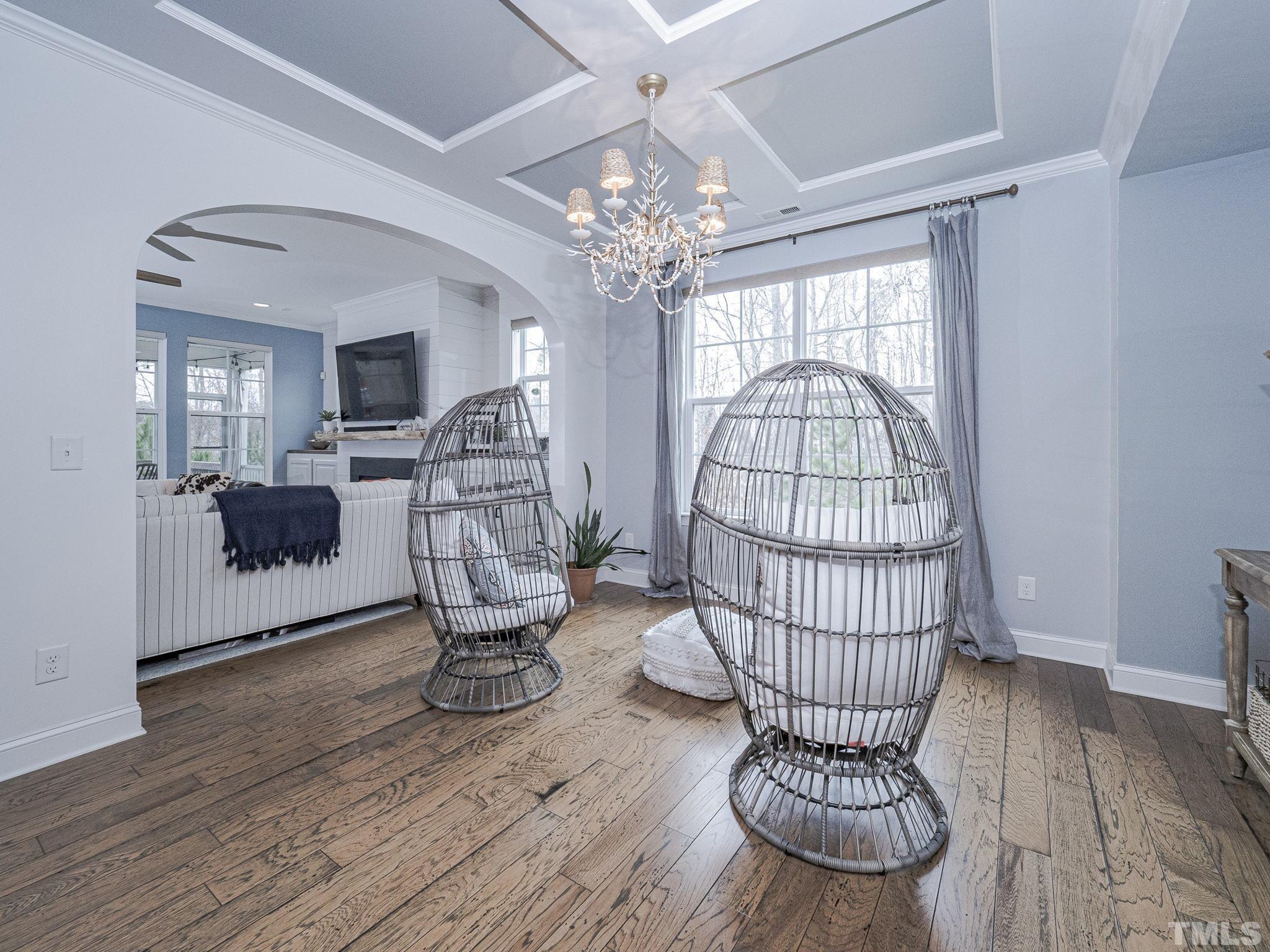 1990 Mostyn Lane Apex, NC 27502 - Photo 7 of 41 a living room with furniture a chandelier and a wooden floor
