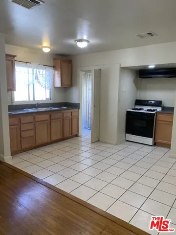 a large kitchen with stainless steel appliances granite countertop a refrigerator and a stove top oven