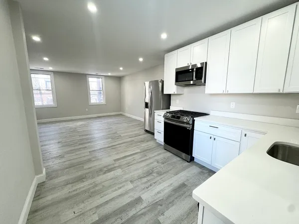 a kitchen with granite countertop a stove a sink and a microwave