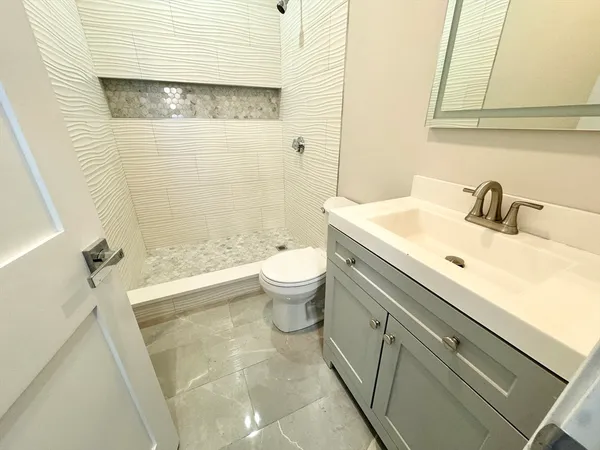 a bathroom with a sink a toilet and shower