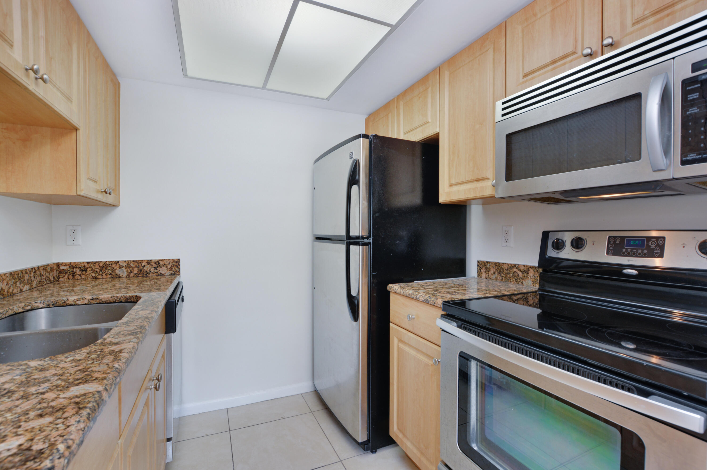 1000 Northeast 9th Avenue, Unit 8 Delray Beach, FL 33483 - Photo 5 of 10 a kitchen with a stove microwave and refrigerator
