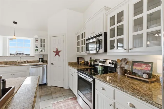 a kitchen with stainless steel appliances granite countertop a stove and cabinets