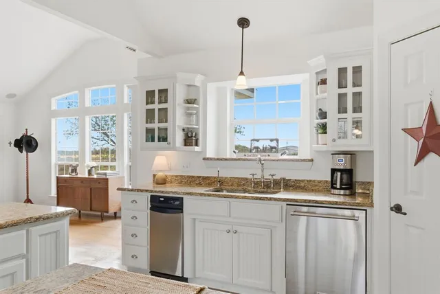 a kitchen with stainless steel appliances granite countertop a sink and a stove