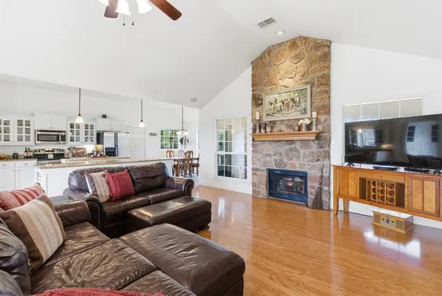 a living room with furniture a fireplace and kitchen view