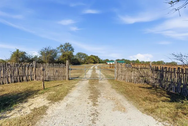 a view of a yard with wooden fence