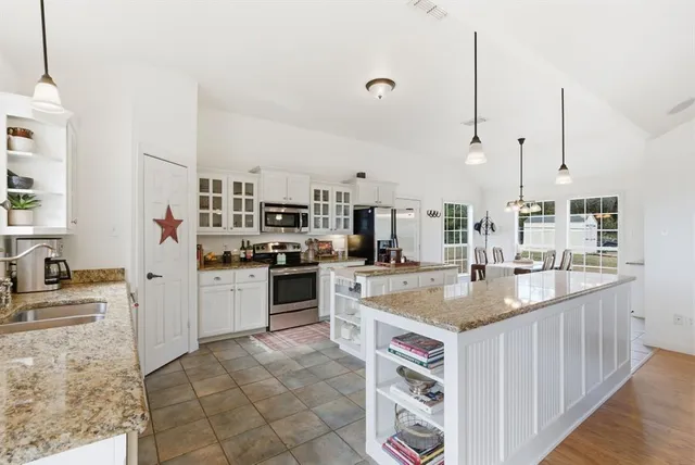 a kitchen with stainless steel appliances granite countertop a sink and a stove