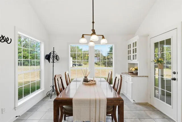 a dining room with furniture a chandelier and wooden floor