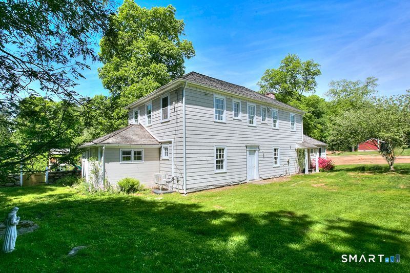 94 Honey Hill Road Wilton, CT 06897 - Photo 16 of 18 a front view of house with yard and green space