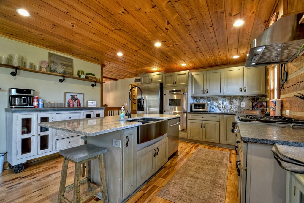 1276 Timber Lake Road Blue Ridge, GA 30513 - Photo 29 of 50 a kitchen with stainless steel appliances granite countertop a sink a stove and cabinets