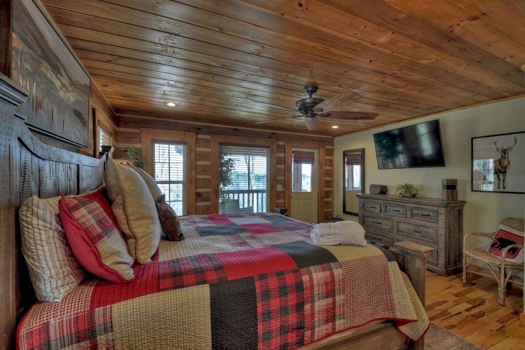 1276 Timber Lake Road Blue Ridge, GA 30513 - Photo 33 of 50 a spacious bedroom with a bed a dresser and flat screen tv